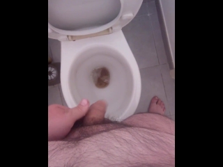 Jeune mec poilu pisse aux toilettes